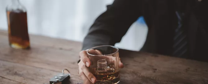Glass of whiskey with car keys highlights dangers of DUI in West Virginia.